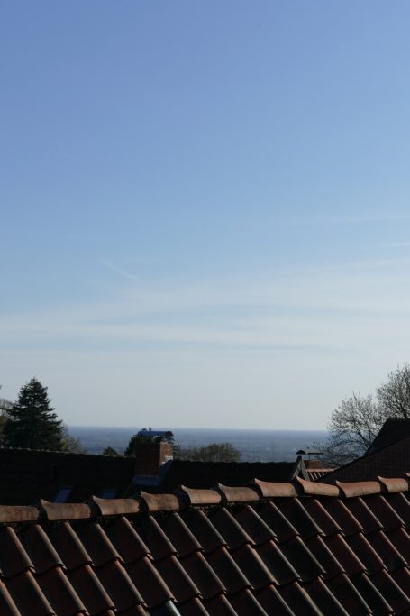 Helle Himmel über Dächern mit weitem Blick auf die Landschaft.